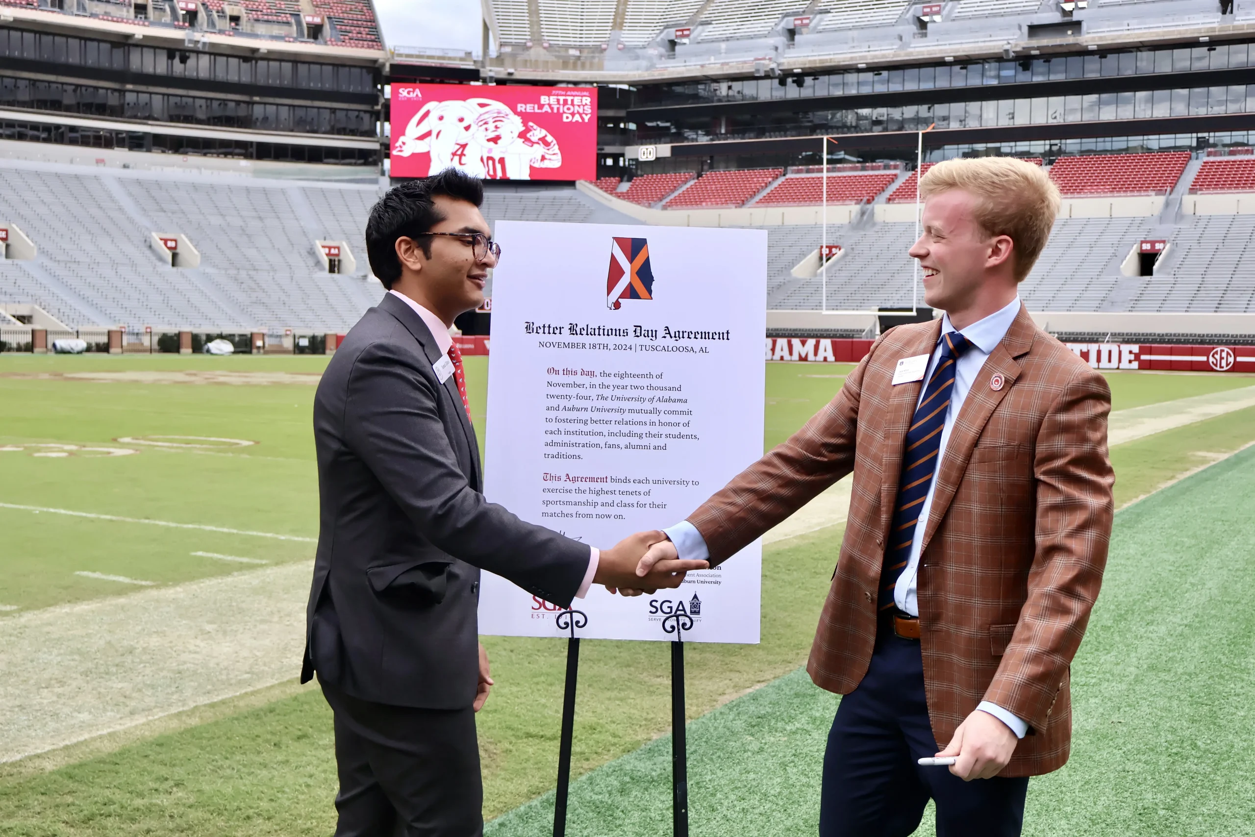 Photo of Auburn SGA President Jack Hilton and Alabama SGA President Samad Gillani shaking hands after signing the better relations agreement